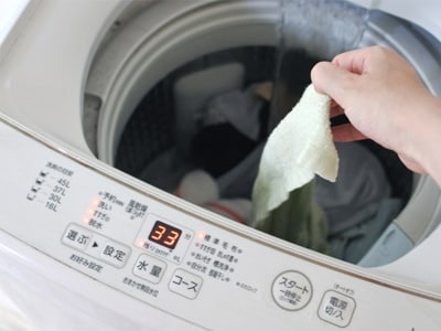 縦型洗濯機に衣類を投入するイメージ