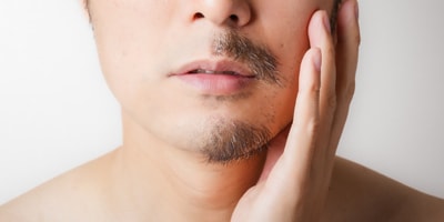 半分ヒゲを剃った男性